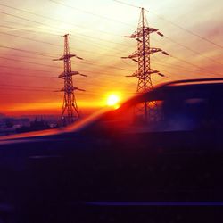 Silhouette of electricity pylon at sunset