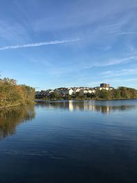 Scenic view of lake by building against sky