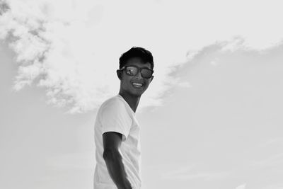 Portrait of young man standing against sky