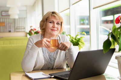 Portrait of a young woman using laptop