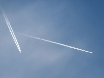 Low angle view of airplane flying against clear blue sky