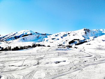 Scenic view of snowcapped mountains against clear blue sky