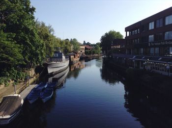 Canal amidst buildings in city against sky