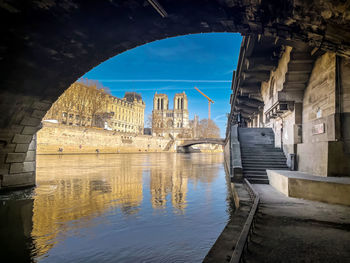 Arch bridge over river against sky