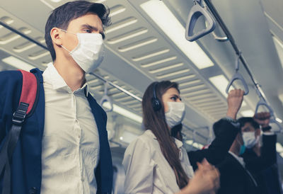 People on the train wear anti-virus masks and travel during rush hours. passengers inside the sky 