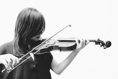 Female violinist playing violin against white background