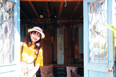 Portrait of smiling young woman in sun hat indoors