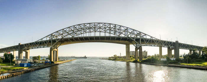 Bridge over river against sky in city