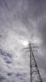 Low angle view of silhouette electricity pylon against sky