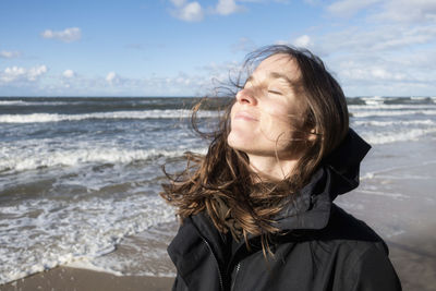 Poland, misdroy, woman enjoying the sunshine on the beach