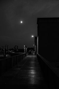 Empty illuminated street amidst buildings at night