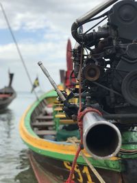 Close-up of coin-operated binoculars by sea against sky