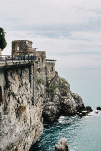 Scenic view of built structure on rocky coast