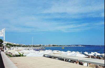 Sailboats moored on sea against sky