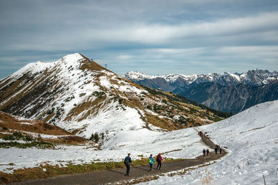 People on snowcapped mountain against sky