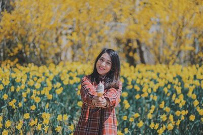 Portrait of smiling young woman standing on field