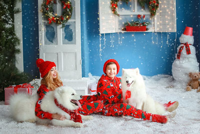Portrait of woman with dog on snow covered field