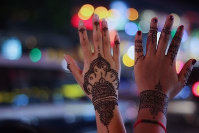 Cropped hands of women with henna tattoo