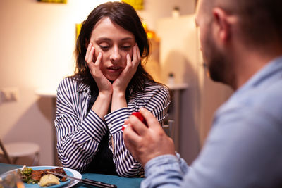 Portrait of young woman having food at home