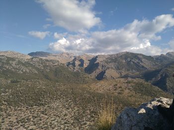 Scenic view of rocky mountains against cloudy sky