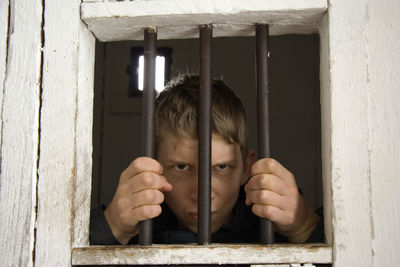 Portrait of boy looking through window