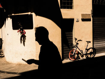 Man with bicycle on street in city