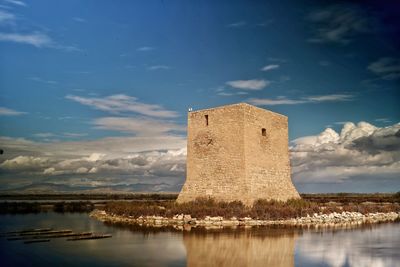 Castle by lake against sky