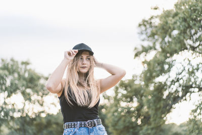 Portrait of beautiful woman standing against sky