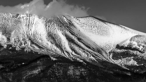 Close-up of snow covered mountain against sky