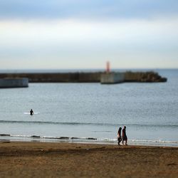 Men on beach against sky