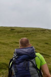 Rear view of man on arid landscape against sky