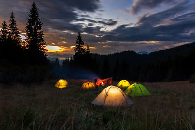 Evening in the ukrainian carpathians. tents glowing on the lawn