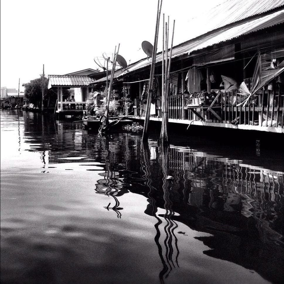 water, reflection, built structure, moored, architecture, nautical vessel, transportation, waterfront, building exterior, boat, mode of transport, canal, sky, river, harbor, clear sky, in a row, outdoors, day, lake