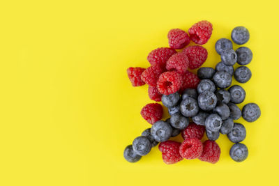 Close-up of strawberries in plate against yellow background