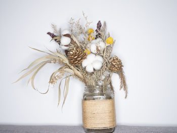 Close-up of flower vase on table against white background