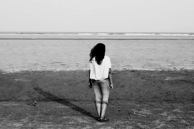 Rear view of woman standing on beach