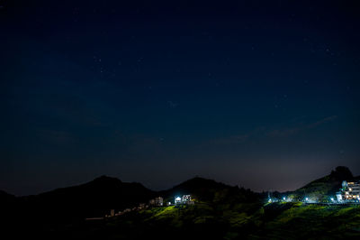 Scenic view of illuminated mountains against sky at night