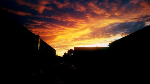 Buildings against cloudy sky at sunset