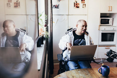 Disabled man with laptop in recording studio