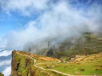 Scenic view of mountains against cloudy sky