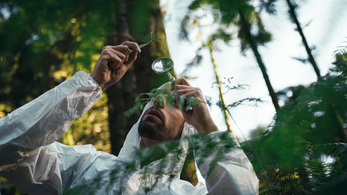 Biologist scientist analyzes the leaves of an endangered plant in the mountains