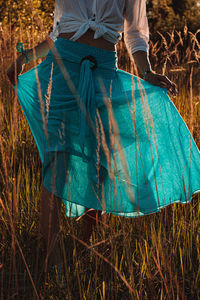 Low section of woman standing on field