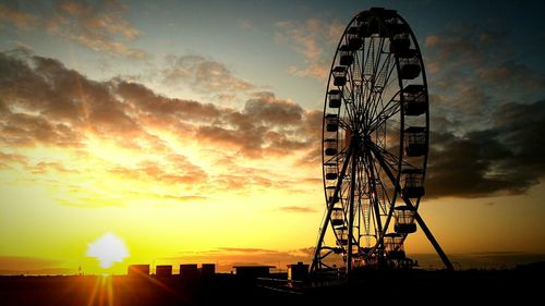 Low angle view of silhouette ferris wheel against sky during sunset