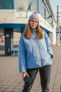 Portrait of young woman standing on street