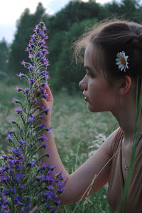 Side view of woman holding plant