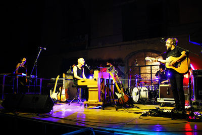 People playing at music concert at night