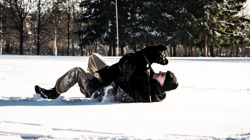 Man with dog on snow covered landscape