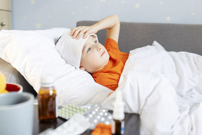 Portrait of young woman lying on bed at home