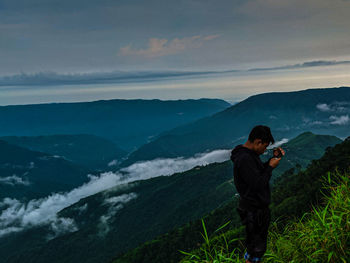 Man standing on mountain against sky