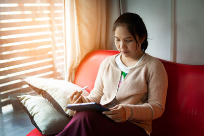 Young woman using mobile phone at home